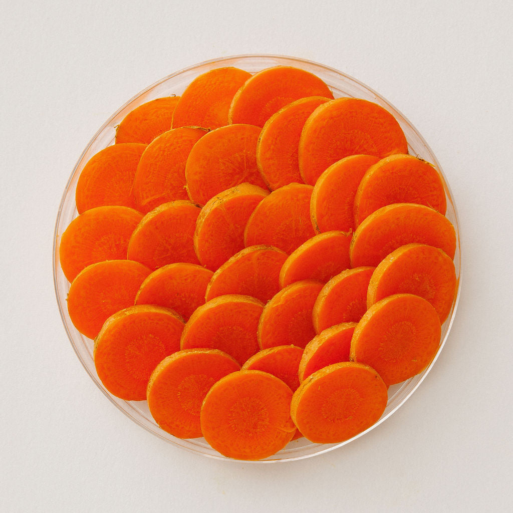 Fresh carrots in a glass dish, viewed from above.