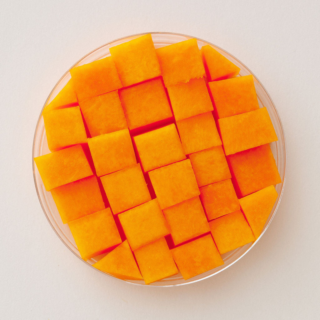 Fresh kabocha squash in a glass dish, viewed from above.