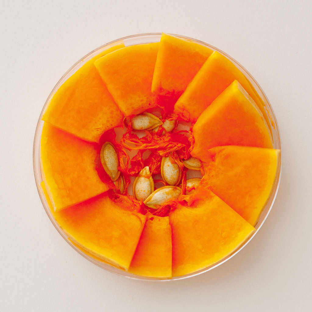 Fresh pumpkin in a glass dish, viewed from above.