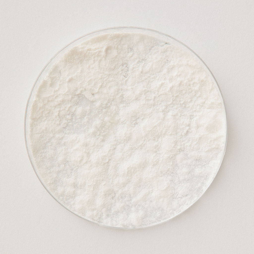 A glass dish of white tapioca starch powder, viewed from above.
